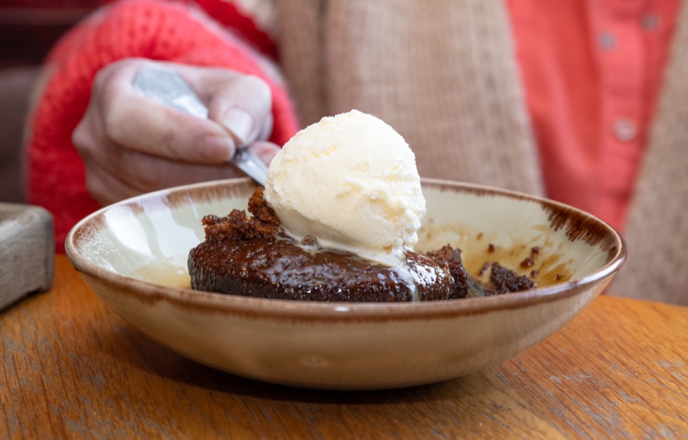 Sticky toffee pudding with vanilla ice cream, served at The Strands Inn